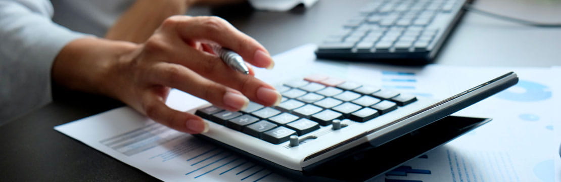 Close up of a woman's hand punching buttons on a calculator.